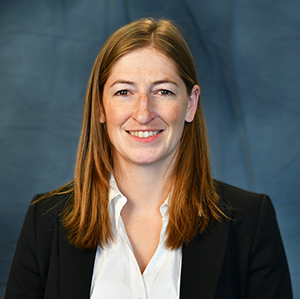 Woman smiling in a white shirt and dark suite