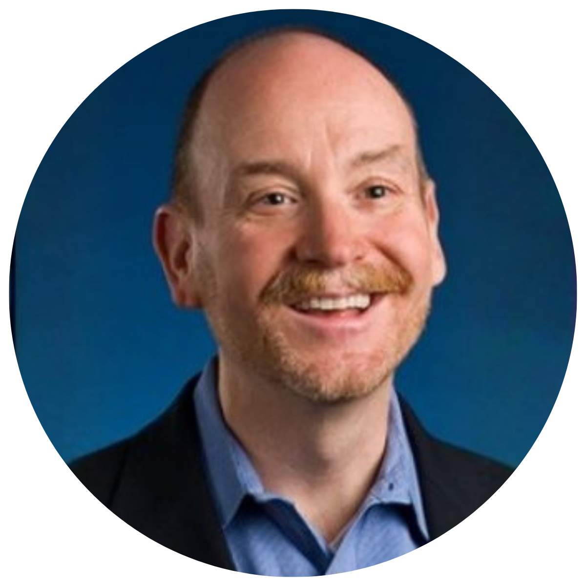 man in black suit and blue shirt smiling