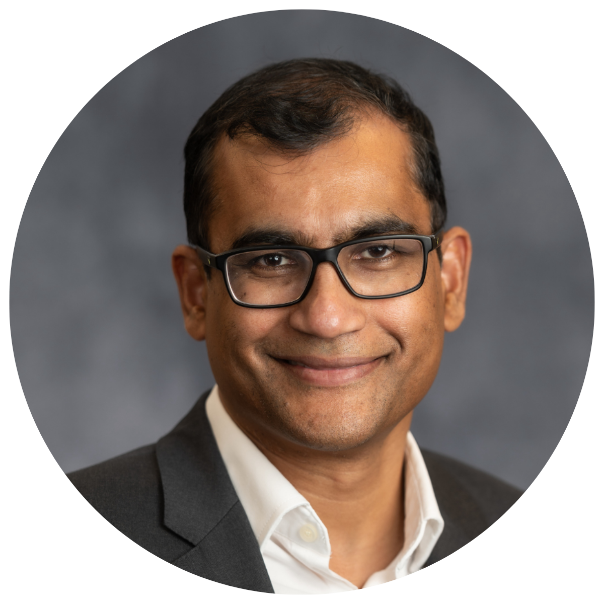 man in dark suite and white shirt wearing glasses