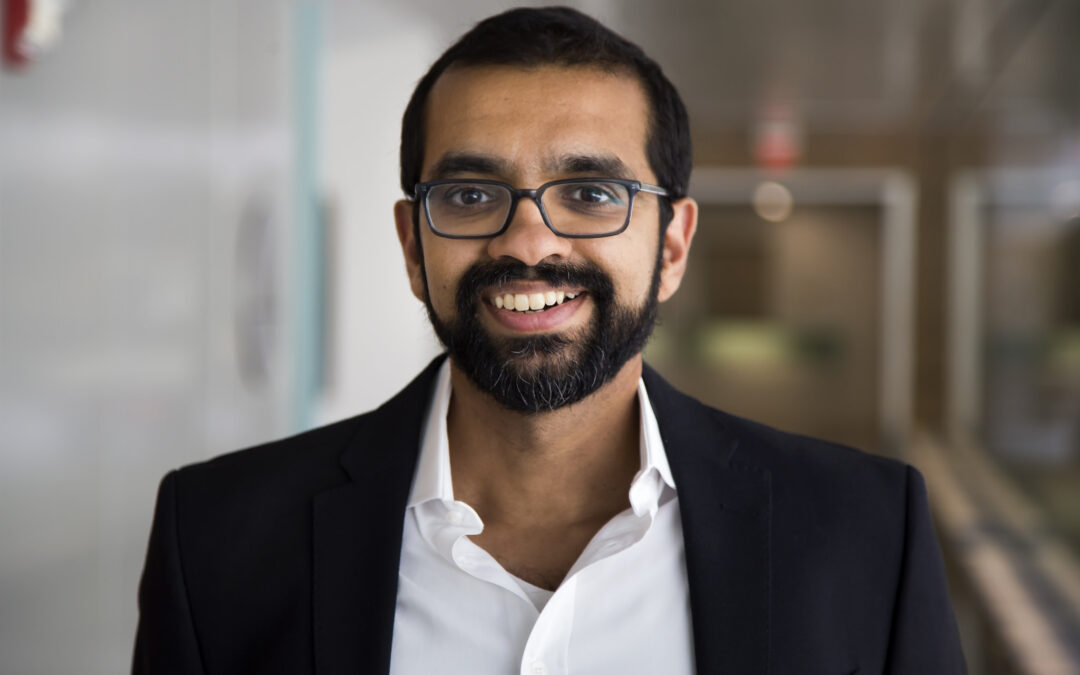 Headshot, wearing glasses, a collared shirt and sport jacket.