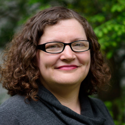 Headshot, wearing glasses, a collared shirt and sport jacket.