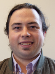 Man in brown sweater smiling