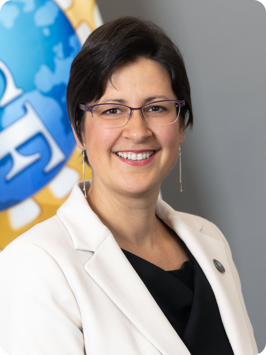 Brown-haired woman wearing glasses and a white lab coat